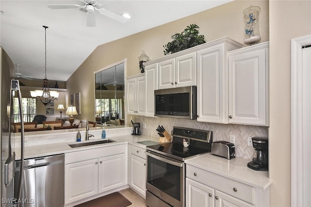3665 Buttonwood Way Unit 1422, Naples, FL 34112 - kitchen featuring appliances with stainless steel finishes, a sink, ceiling fan with notable chandelier, lofted ceiling, and tasteful backsplash