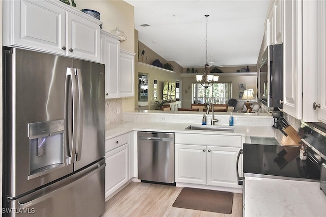 3665 Buttonwood Way Unit 1422, Naples, FL 34112 - kitchen featuring a notable chandelier, a sink, stainless steel appliances, white cabinetry, and lofted ceiling