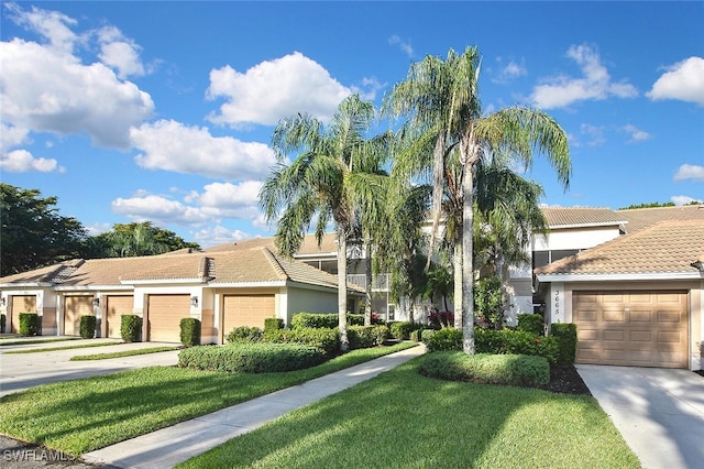 3665 Buttonwood Way Unit 1422, Naples, FL 34112 - view of front of house with concrete driveway, a tile roof, a front yard, and stucco siding