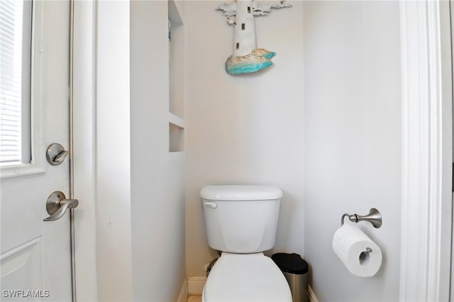bathroom featuring baseboards and toilet