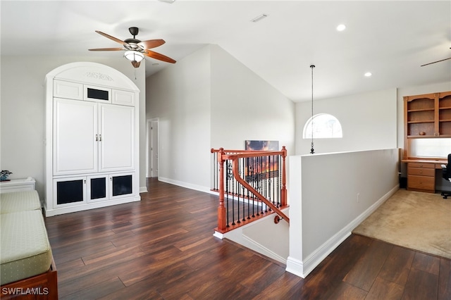 interior space with baseboards, an upstairs landing, wood finished floors, and lofted ceiling