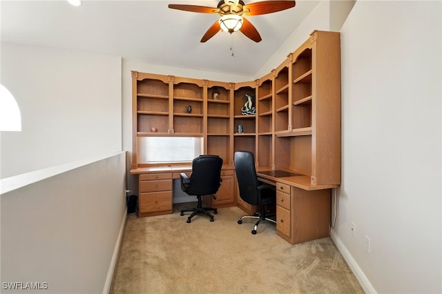 unfurnished office featuring light colored carpet, a ceiling fan, and baseboards
