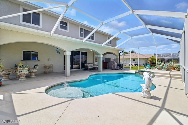 pool featuring glass enclosure and a patio area