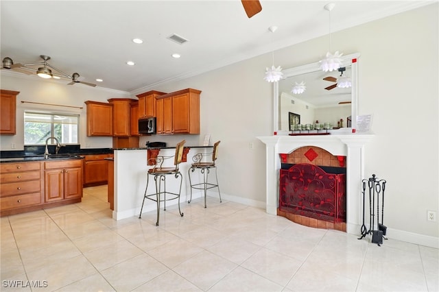 kitchen featuring crown molding, a ceiling fan, stainless steel microwave, and dark countertops
