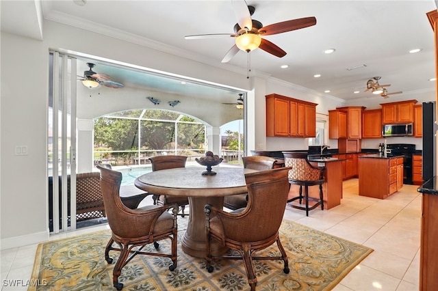 dining area featuring ceiling fan, ornamental molding, and light tile patterned floors