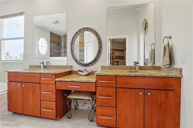 bathroom featuring a sink, a tile shower, and two vanities