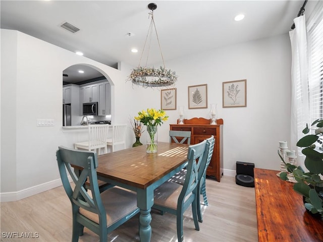 15780 Portofino Springs Blvd Unit 106, Fort Myers, FL 33908 - dining area with visible vents, baseboards, recessed lighting, arched walkways, and light wood finished floors
