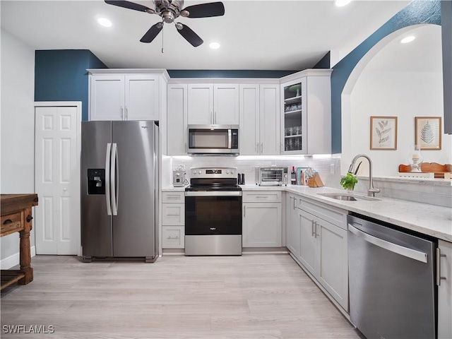15780 Portofino Springs Blvd Unit 106, Fort Myers, FL 33908 - kitchen featuring a ceiling fan, light stone countertops, a sink, white cabinets, and stainless steel appliances