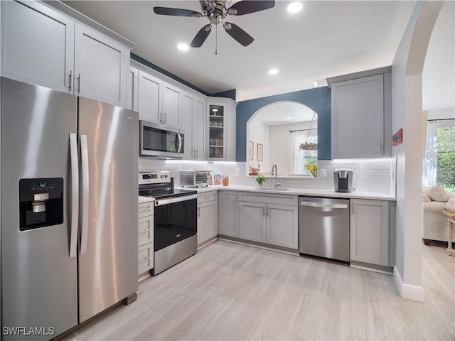 15780 Portofino Springs Blvd Unit 106, Fort Myers, FL 33908 - kitchen with ceiling fan, backsplash, arched walkways, a sink, and stainless steel appliances