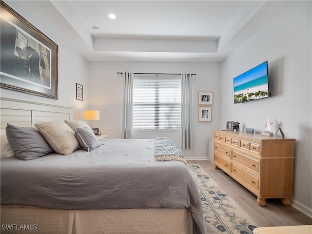 15780 Portofino Springs Blvd Unit 106, Fort Myers, FL 33908 - bedroom featuring baseboards, light wood finished floors, and a raised ceiling