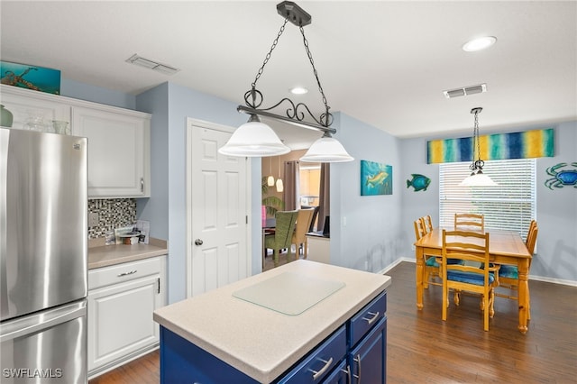 kitchen featuring blue cabinetry, visible vents, baseboards, freestanding refrigerator, and white cabinetry