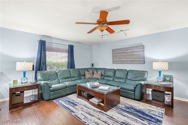 living room featuring a ceiling fan, baseboards, track lighting, and wood finished floors