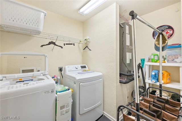 washroom with washer and dryer, laundry area, and a textured wall