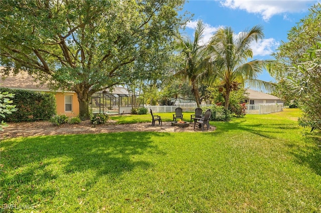 view of yard featuring an outdoor fire pit and fence