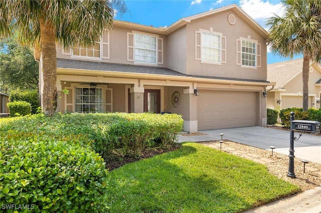 traditional home with an attached garage, driveway, and stucco siding