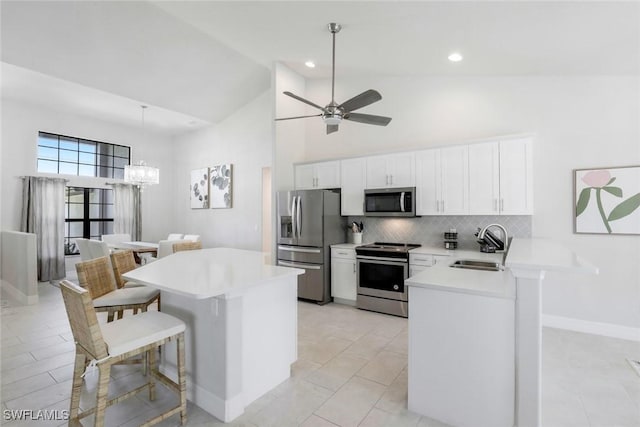 2016 SW 28th Ln, Cape Coral, FL 33914 - kitchen with a breakfast bar area, appliances with stainless steel finishes, a sink, and high vaulted ceiling
