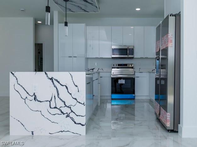 kitchen featuring appliances with stainless steel finishes, light countertops, marble finish floor, white cabinetry, and modern cabinets
