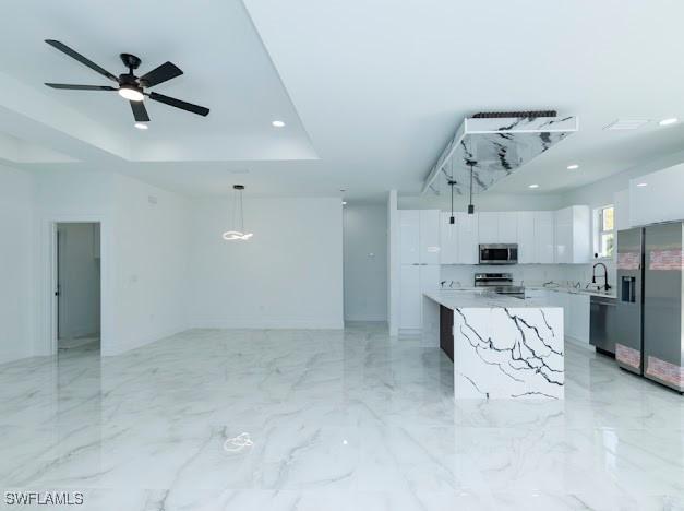 kitchen featuring ceiling fan, a center island, stainless steel appliances, recessed lighting, and white cabinetry