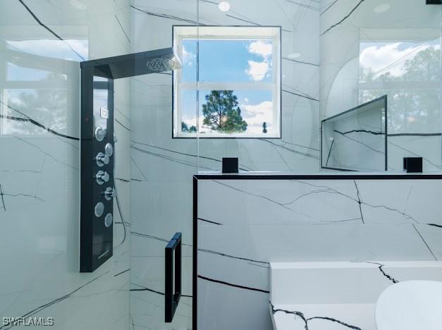 full bathroom featuring a marble finish shower