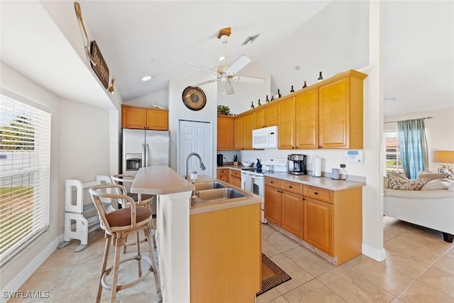 209 SE 3rd Ter, Cape Coral, FL 33990 - kitchen featuring a ceiling fan, a breakfast bar, a sink, white appliances, and lofted ceiling