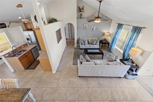 209 SE 3rd Ter, Cape Coral, FL 33990 - living room featuring a ceiling fan, lofted ceiling, baseboards, light tile patterned flooring, and arched walkways