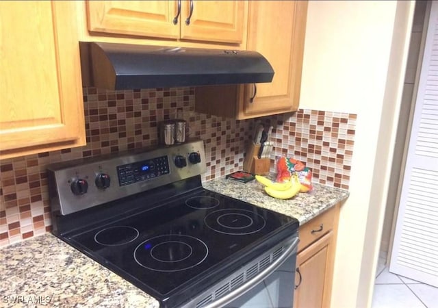 303 Georgia Ave, Fort Myers, FL 33905 - kitchen featuring under cabinet range hood, backsplash, light brown cabinetry, and stainless steel range with electric cooktop