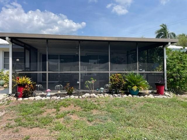 303 Georgia Ave, Fort Myers, FL 33905 - back of house featuring a yard and a sunroom