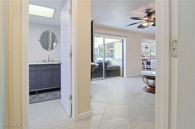 147 Coral Dr, Fort Myers, FL 33905 - hallway with light tile patterned floors, baseboards, and a sink