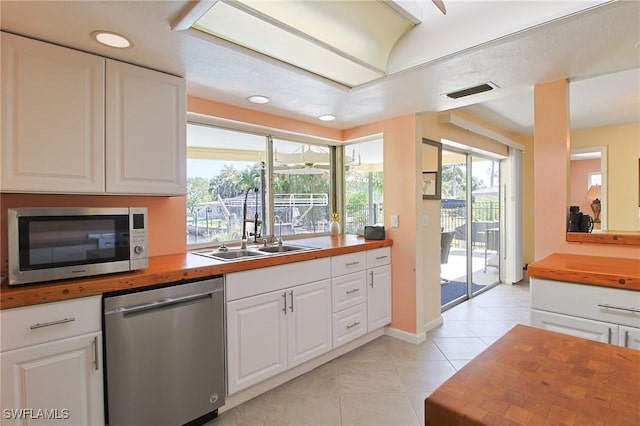 147 Coral Dr, Fort Myers, FL 33905 - kitchen with white cabinetry, butcher block counters, appliances with stainless steel finishes, and a sink