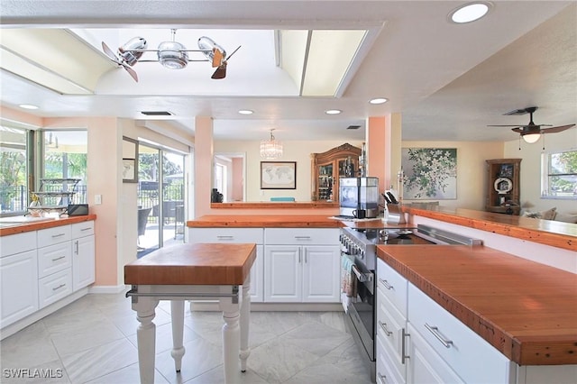 147 Coral Dr, Fort Myers, FL 33905 - kitchen featuring wood counters, recessed lighting, ceiling fan, white cabinetry, and stainless steel range