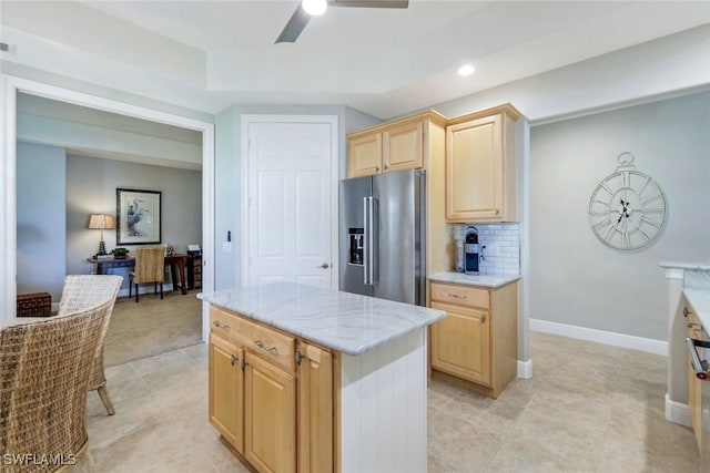 kitchen featuring light brown cabinetry, high end fridge, ceiling fan, light stone counters, and backsplash