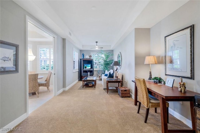 office with a ceiling fan, baseboards, light colored carpet, and visible vents