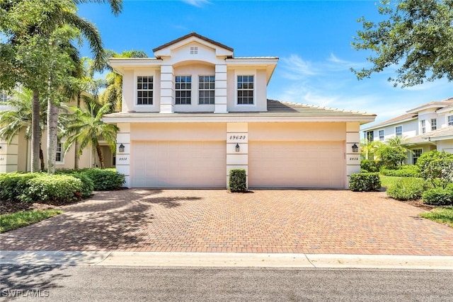mediterranean / spanish-style house featuring decorative driveway, a garage, and stucco siding