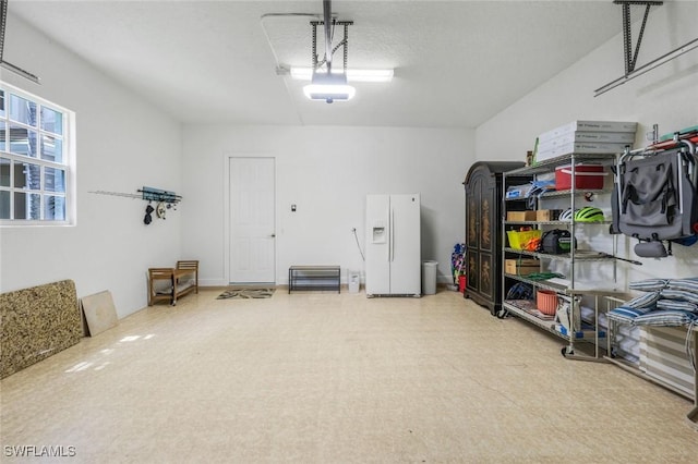 garage featuring white refrigerator with ice dispenser