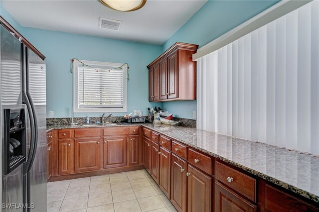 13515 Eagle Ridge Dr Unit 522, Fort Myers, FL 33912 - kitchen with visible vents, light tile patterned flooring, stainless steel fridge, dark stone counters, and a sink