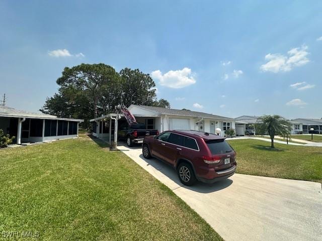 view of front of home featuring a sunroom, driveway, and a front yard