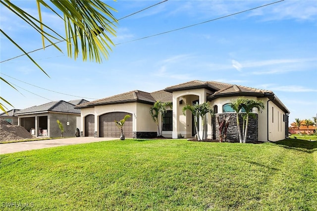 mediterranean / spanish home with stone siding, a front yard, stucco siding, an attached garage, and driveway
