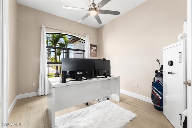 office featuring baseboards, a ceiling fan, and light wood finished floors