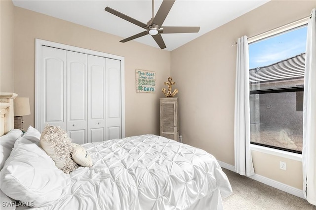 bedroom with a closet, carpet flooring, baseboards, and ceiling fan
