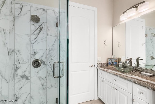 bathroom with a marble finish shower and vanity
