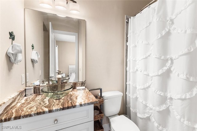 full bathroom with toilet, curtained shower, and vanity