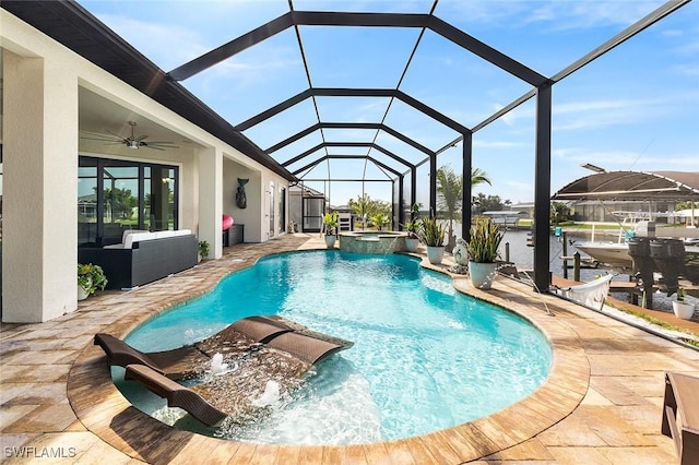 view of pool featuring glass enclosure, a patio area, a pool with connected hot tub, and ceiling fan