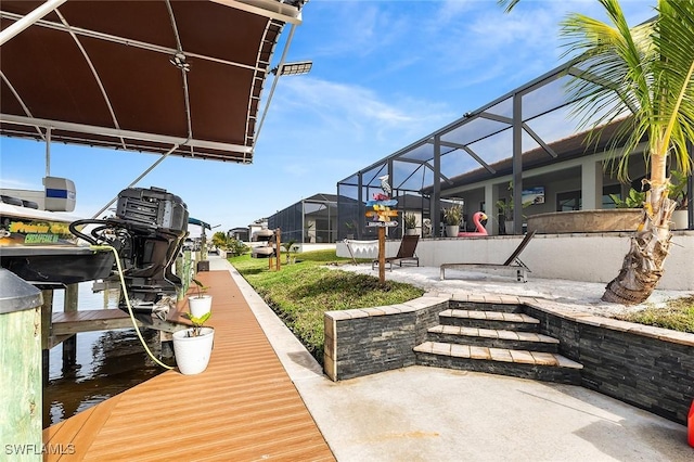 view of dock featuring glass enclosure, boat lift, a water view, and a patio area