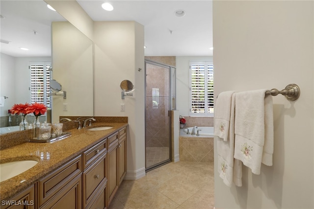bathroom featuring a sink, double vanity, tile patterned floors, a bath, and a stall shower