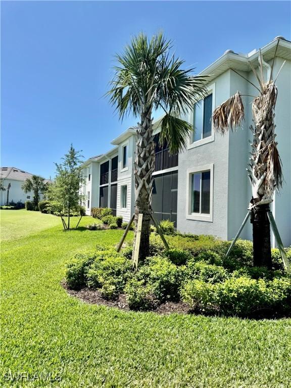 5445 Double Eagle Cir Unit 3012, Ave Maria, FL 34142 - rear view of house with a lawn and stucco siding