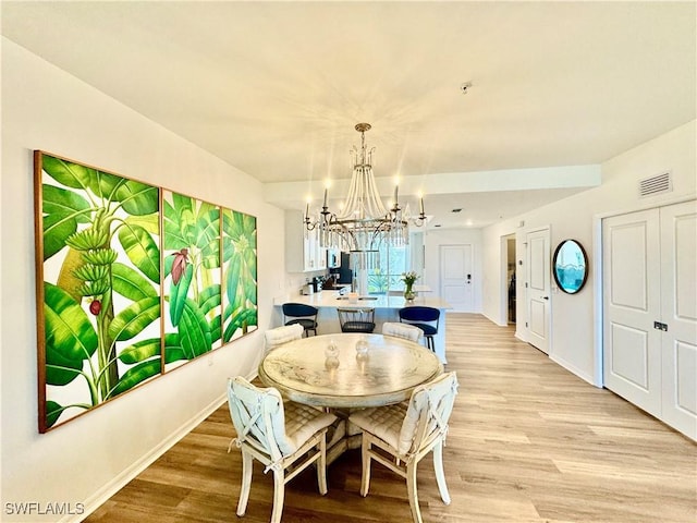 5445 Double Eagle Cir Unit 3012, Ave Maria, FL 34142 - dining room with a chandelier, light wood-style flooring, and baseboards