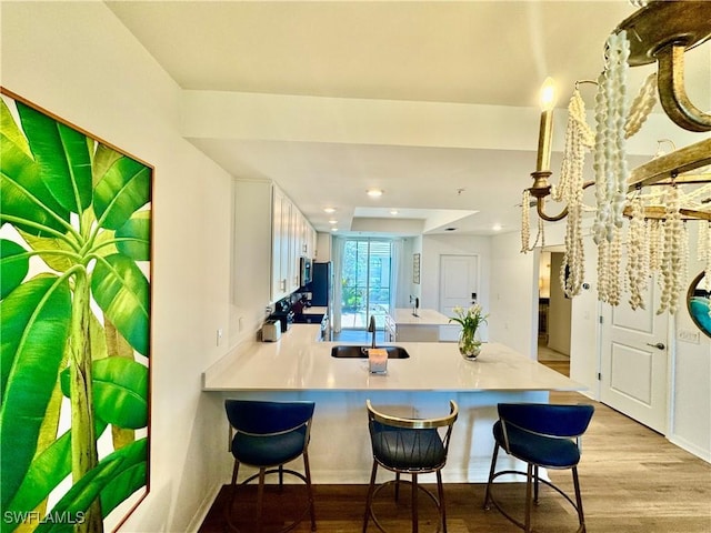 5445 Double Eagle Cir Unit 3012, Ave Maria, FL 34142 - kitchen with a peninsula, a kitchen breakfast bar, a sink, light countertops, and recessed lighting