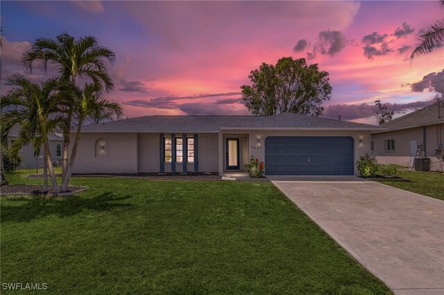 1424 SW 49th St, Cape Coral, FL 33914 - single story home with driveway, an attached garage, a lawn, and stucco siding