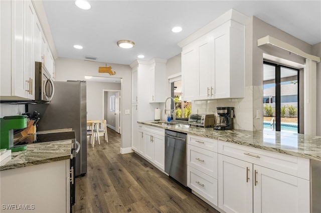 1424 SW 49th St, Cape Coral, FL 33914 - kitchen featuring appliances with stainless steel finishes, a sink, white cabinets, dark wood-style flooring, and baseboards