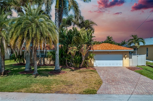 5122 Santa Rosa Ct, Cape Coral, FL 33904 - view of front facade with fence, a front lawn, stucco siding, decorative driveway, and a tiled roof